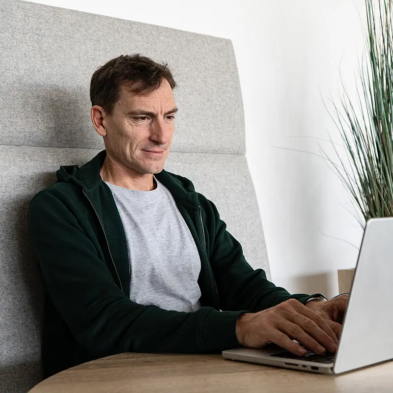 An employee working on CUORE's design assistant on a laptop
